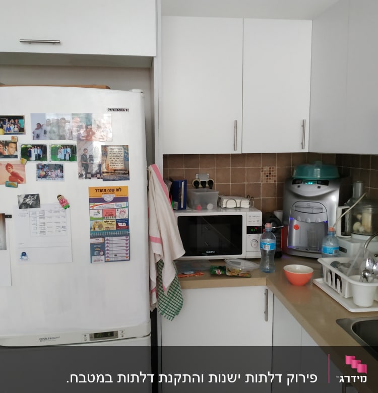 מטבח עם מקרר, מיקרוגל וכלים בכיור